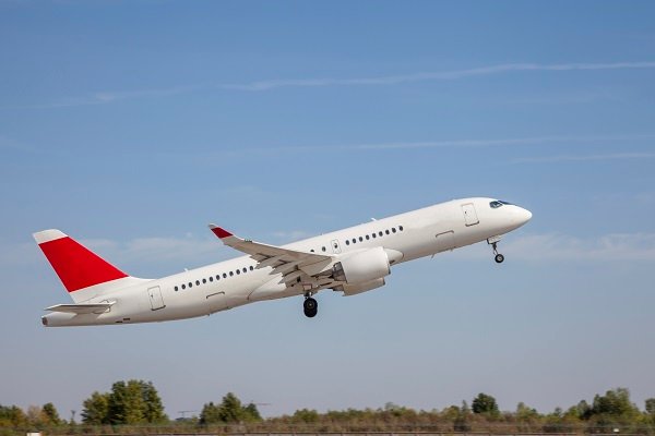White plane flies in the sky. Takeoff and landing. Arrival and departure. Place for your text. Passenger plane isolated on blue background. Passenger airplane. Travel by air transport. Flying.